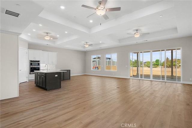 26176 Boulder View Ct, Menifee, CA 92584 - unfurnished living room with a raised ceiling, light wood-type flooring, ceiling fan, and recessed lighting