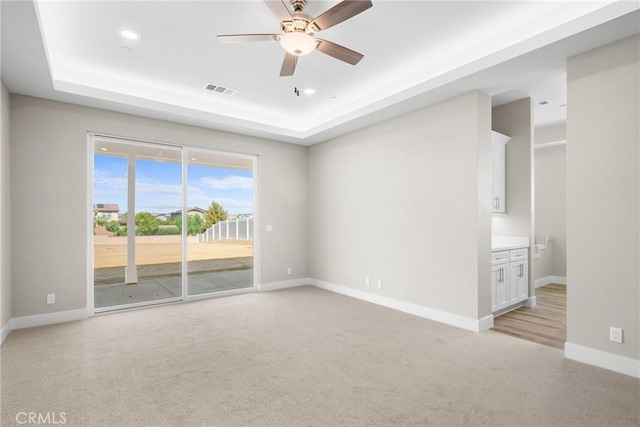 26176 Boulder View Ct, Menifee, CA 92584 - spare room with light carpet, a tray ceiling, a ceiling fan, and recessed lighting