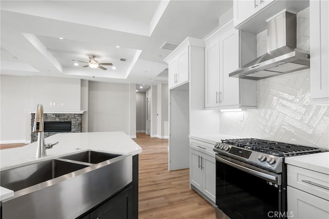 26176 Boulder View Ct, Menifee, CA 92584 - kitchen with stainless steel range with gas cooktop, wall chimney exhaust hood, a tray ceiling, ceiling fan, and light countertops