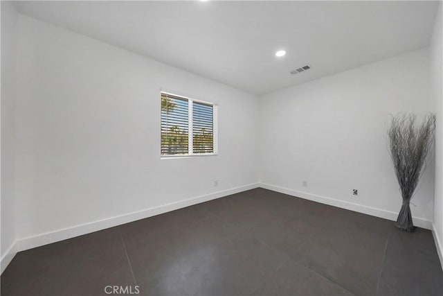 spare room featuring dark tile patterned floors