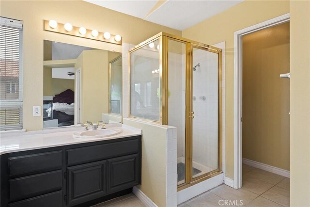 bathroom featuring tile patterned flooring, vanity, and a shower with shower door