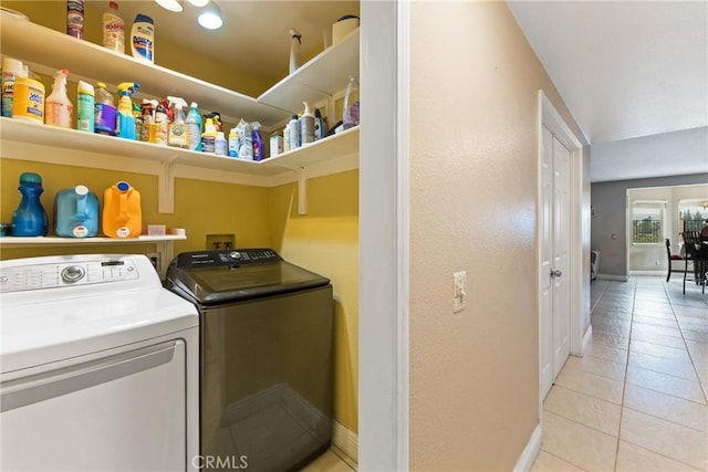 laundry area with separate washer and dryer and light tile patterned flooring