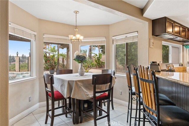 dining area with light tile patterned floors and an inviting chandelier