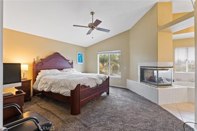 tiled bedroom featuring ceiling fan, lofted ceiling, and a tiled fireplace