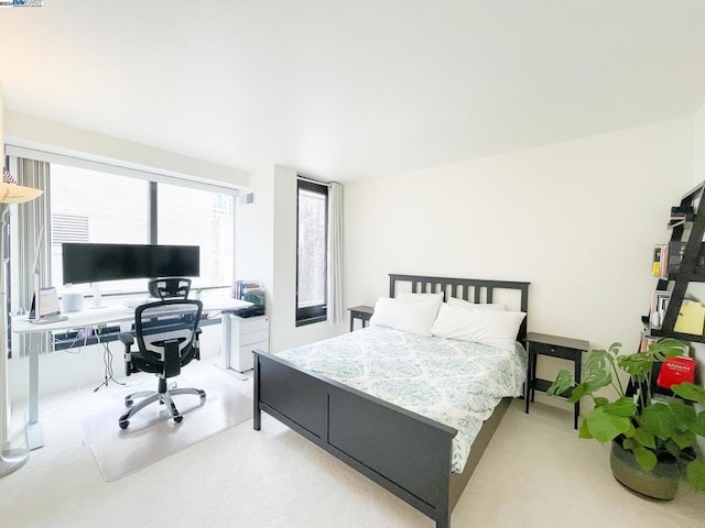 bedroom with light carpet and multiple windows