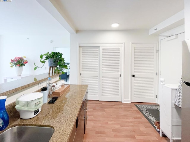 kitchen featuring light stone counters and light hardwood / wood-style floors