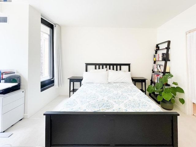 bedroom featuring light carpet and multiple windows