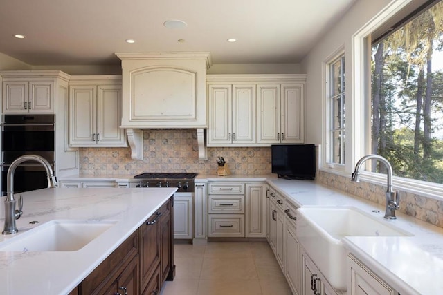 kitchen featuring decorative backsplash, sink, appliances with stainless steel finishes, and light tile patterned flooring