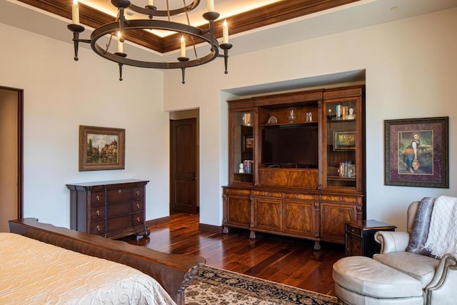 bedroom featuring dark wood-type flooring, ornamental molding, and a notable chandelier