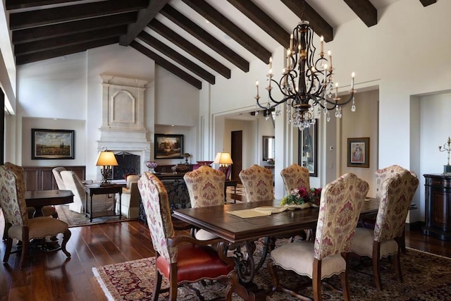 dining space featuring dark hardwood / wood-style flooring, an inviting chandelier, a large fireplace, high vaulted ceiling, and beam ceiling