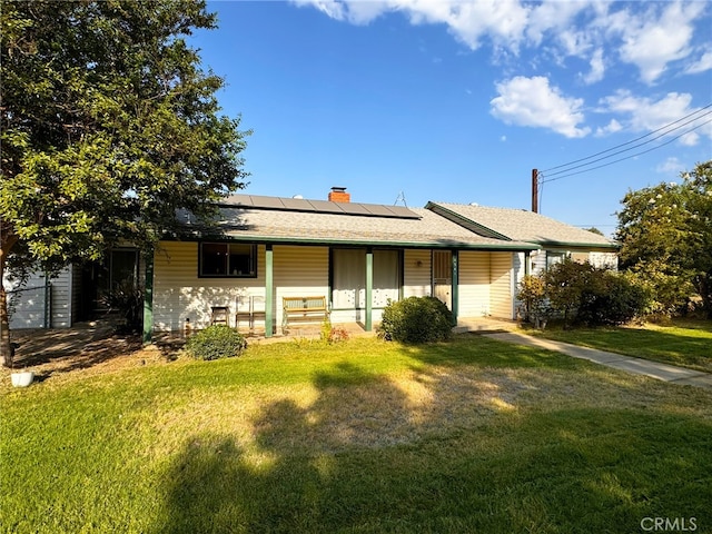 single story home with a porch, solar panels, and a front yard