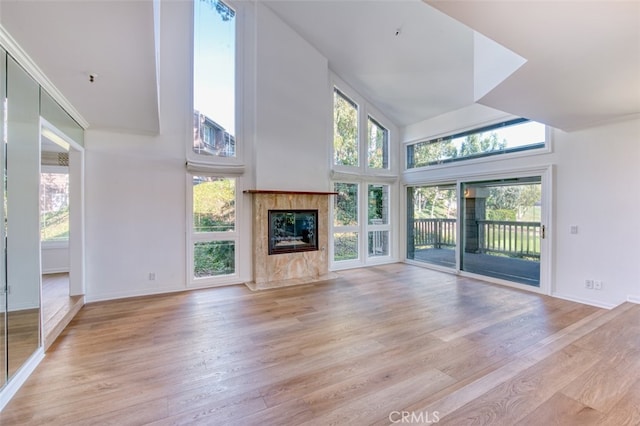 unfurnished living room featuring light hardwood / wood-style flooring, a fireplace, and plenty of natural light