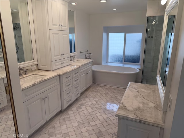 bathroom featuring vanity and independent shower and bath