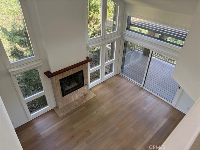 unfurnished living room featuring hardwood / wood-style floors, a healthy amount of sunlight, and a fireplace