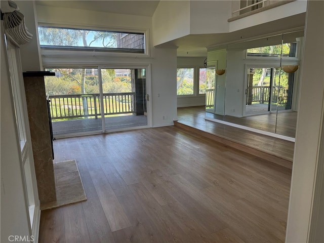 interior space with a towering ceiling and wood-type flooring