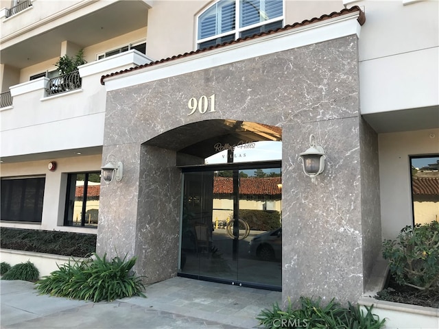 view of exterior entry featuring a balcony