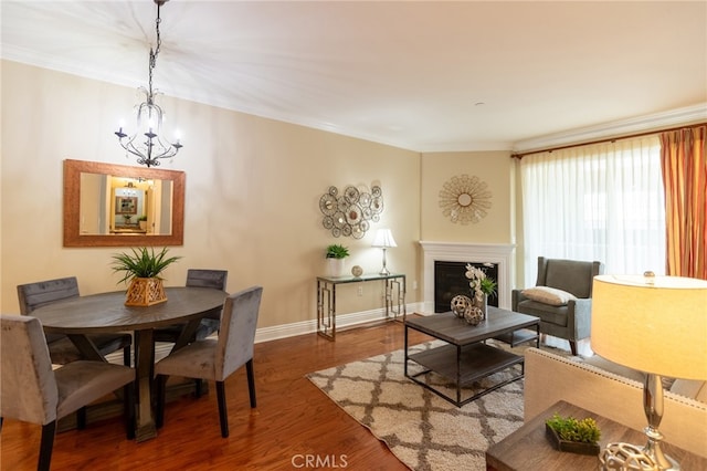 living room featuring hardwood / wood-style floors, crown molding, and a chandelier