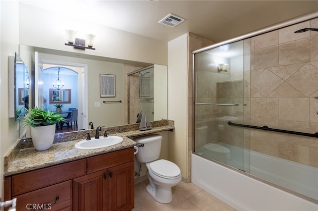 full bathroom with tile patterned flooring, toilet, bath / shower combo with glass door, vanity, and a chandelier