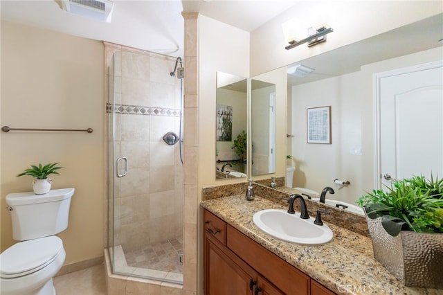 bathroom with vanity, a shower with shower door, toilet, and tile patterned floors