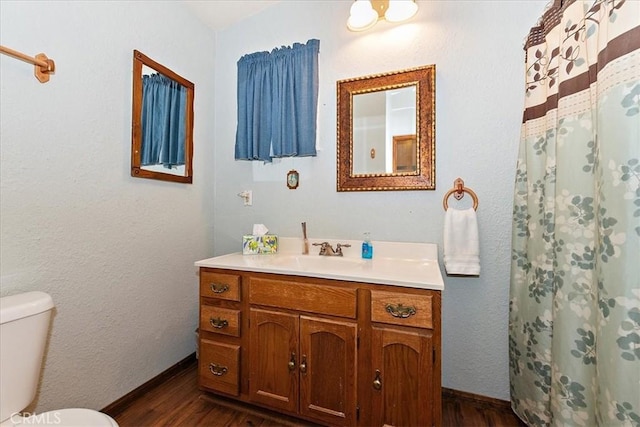 bathroom with walk in shower, vanity, wood-type flooring, and toilet