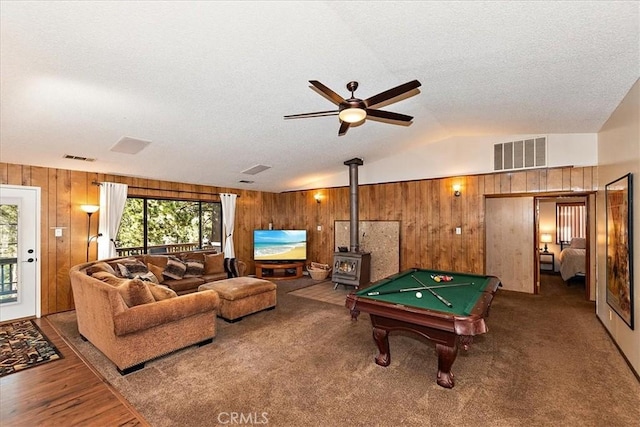 game room with a wood stove, wood walls, hardwood / wood-style floors, lofted ceiling, and pool table