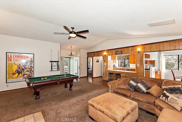 game room with carpet flooring, a textured ceiling, vaulted ceiling, ceiling fan, and wooden walls