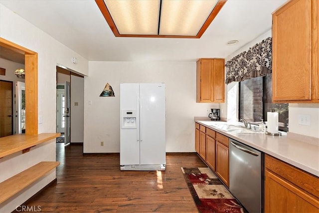 kitchen with stainless steel dishwasher, dark hardwood / wood-style floors, white refrigerator with ice dispenser, and sink