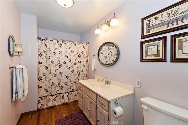 bathroom with toilet, vanity, and hardwood / wood-style flooring