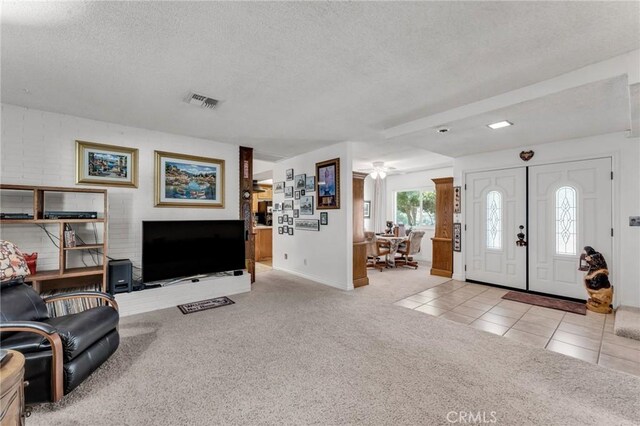 carpeted living room with a textured ceiling and ceiling fan