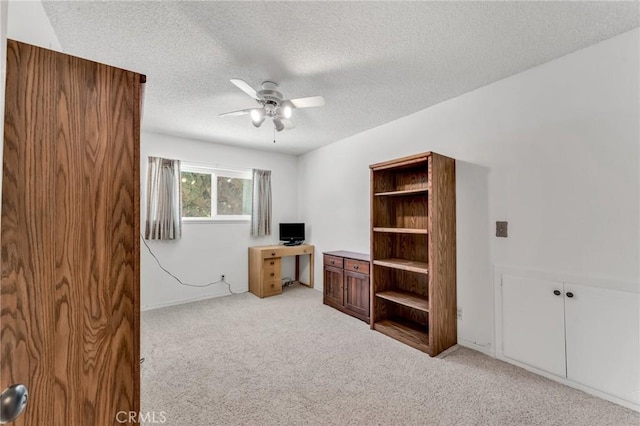 office with ceiling fan, light carpet, and a textured ceiling