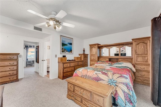 carpeted bedroom featuring ceiling fan and a textured ceiling