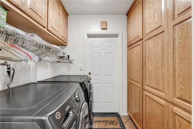 laundry area with cabinets, washer and dryer, and light tile patterned floors