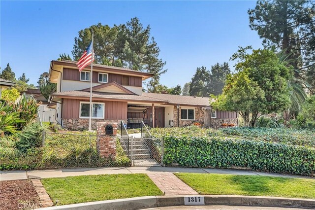 1317 Pacific St, Redlands, CA 92373 - view of front of house featuring stone siding, a gate, a porch, and a fenced front yard
