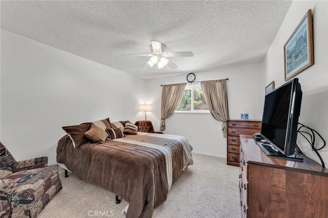 bedroom featuring ceiling fan, light colored carpet, and a textured ceiling