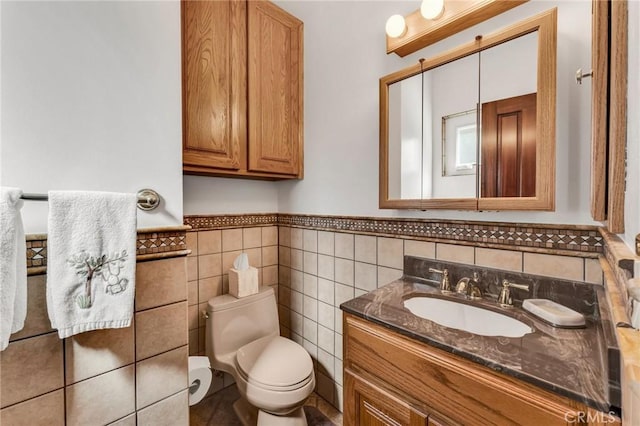 bathroom featuring tile walls, vanity, and toilet