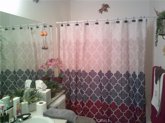 bathroom featuring curtained shower and toilet