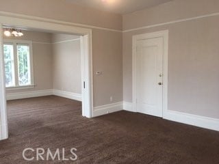 spare room with dark colored carpet