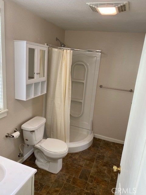 bathroom featuring vanity, curtained shower, and toilet