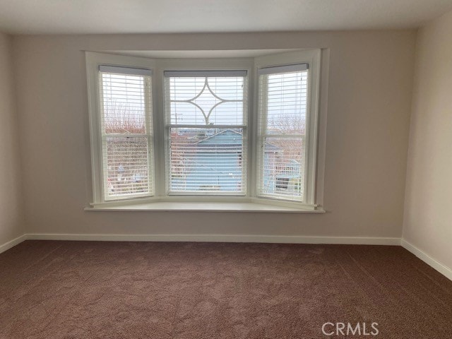 unfurnished room with dark carpet