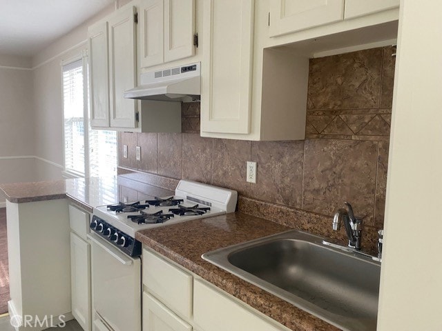 kitchen featuring decorative backsplash, white cabinets, sink, and white gas range oven