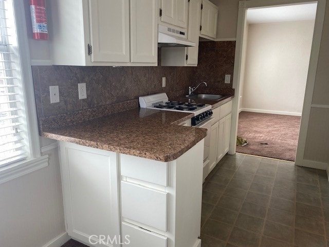 kitchen featuring sink, backsplash, white gas range, custom exhaust hood, and white cabinets