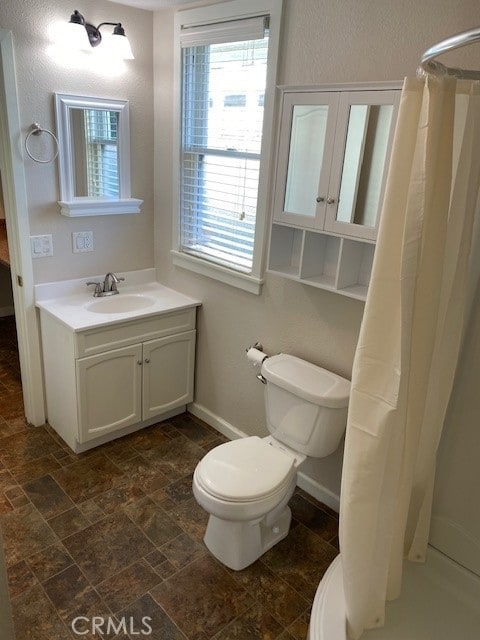 bathroom featuring vanity, toilet, and curtained shower