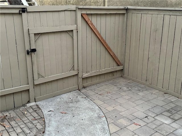 view of gate featuring a patio area