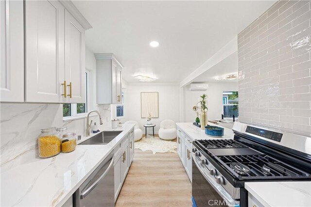 kitchen featuring decorative backsplash, sink, light wood-type flooring, and stainless steel appliances