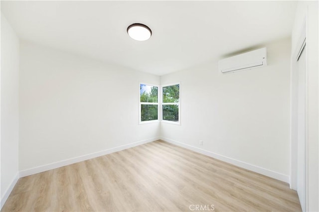 empty room featuring light hardwood / wood-style flooring and a wall mounted AC