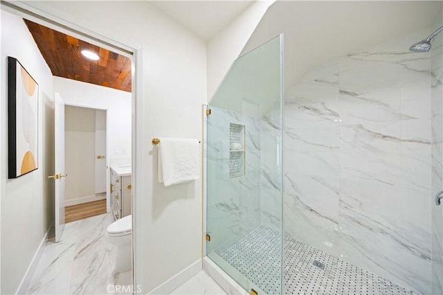 bathroom with a tile shower, vanity, and toilet