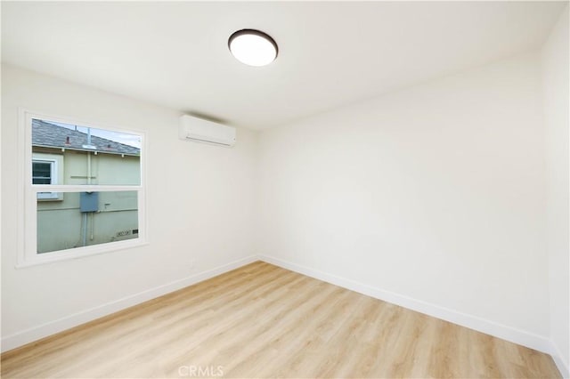 spare room with light wood-type flooring and a wall mounted AC