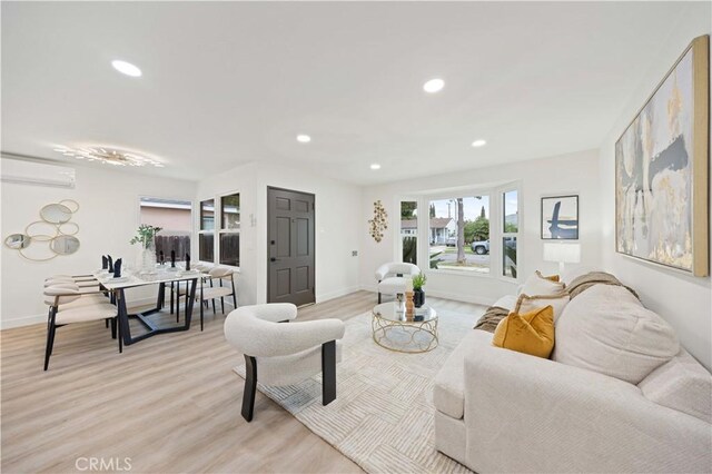 living room with light wood-type flooring and an AC wall unit