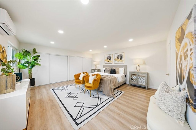 bedroom featuring a wall mounted AC, a closet, and light wood-type flooring