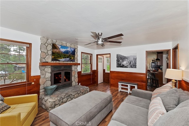 living room with a wealth of natural light, hardwood / wood-style floors, and a stone fireplace